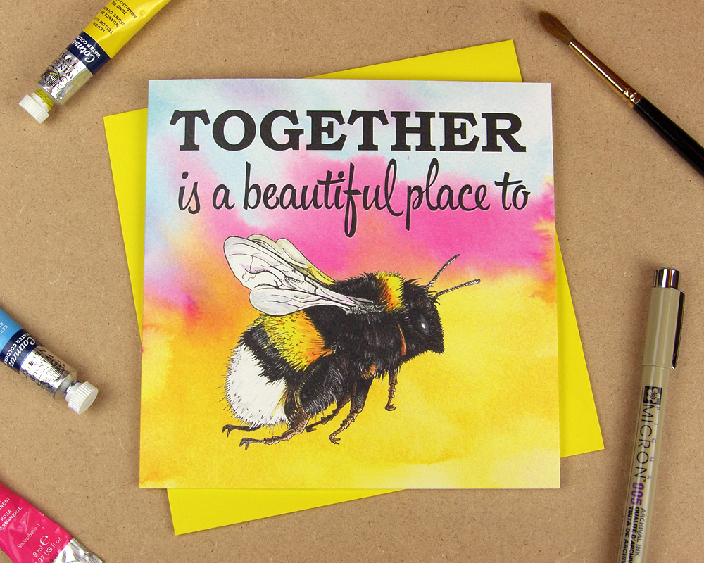 Greetings card with the words 'Together is a beautiful place to be' with the word 'be' replaced with an illustrated bumblebee on multicoloured watercolour background