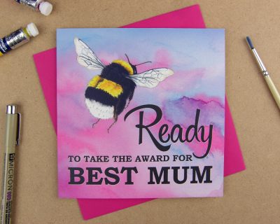 Greetings card with the words 'Be ready to take the award for best mum' with the word 'be' replaced with an illustrated bumblebee on pink watercolour background