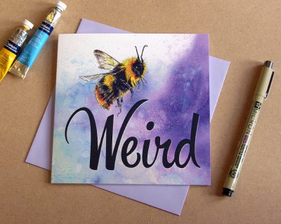 Product shot of be weird greetings card